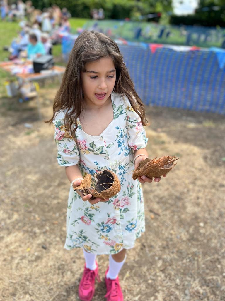 Girl looking surprised holding a broken coconut